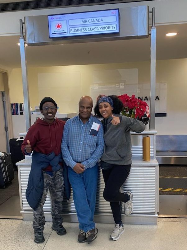Mr. Kidane (center) at the airport ticket check in before leaving for Ethiopia